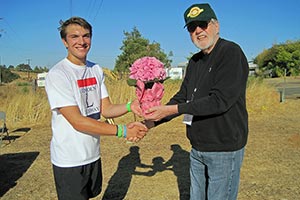 Winner of the Inaugural Lincoln Hwy 8k Fun Run, Brycen Groess, shaking hands with Dr. John Thomson.